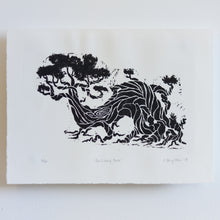 Load image into Gallery viewer, A small, black and white linocut print of a twisted and entangled tree. The tree slopes to the left, and appears to be lively and moving. The print takes up a majority of the paper. It is numbered, titled, and signed underneath the print.
